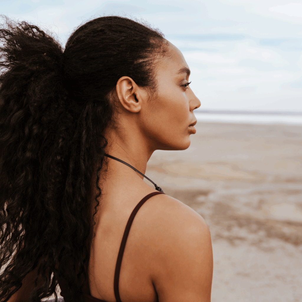 Strong Black woman at the beach staring out into the water | breaking generational cycles