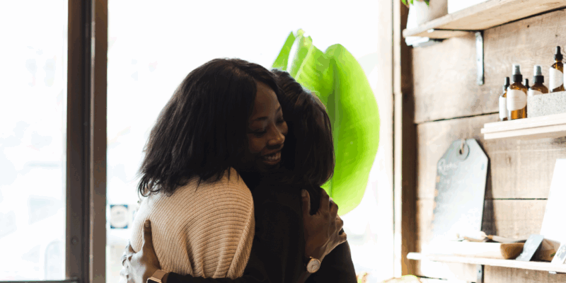 Two black women hugging in a store | Emotional safety