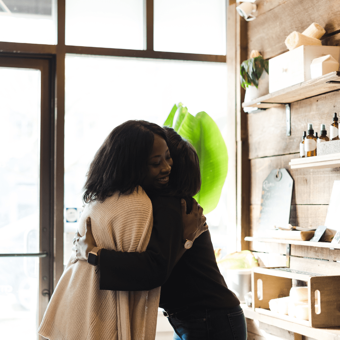 Two black women hugging in a store | Emotional safety