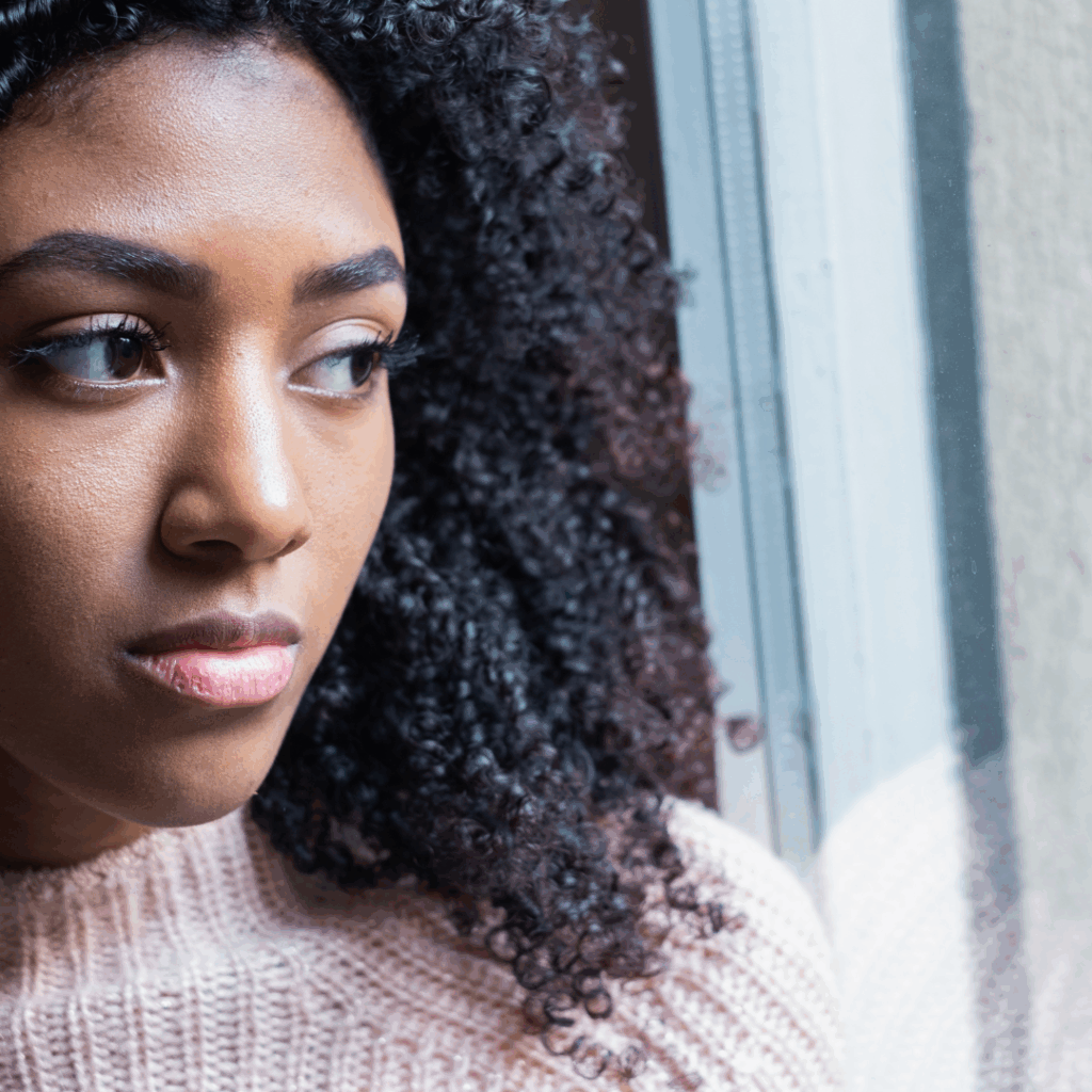 Black woman staring sadly out of the window | Feeling hopeless? Here's how to find hope again