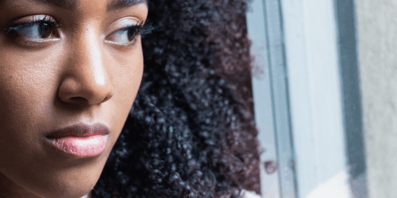 Black woman staring sadly out of the window | Feeling hopeless? Here's how to find hope again