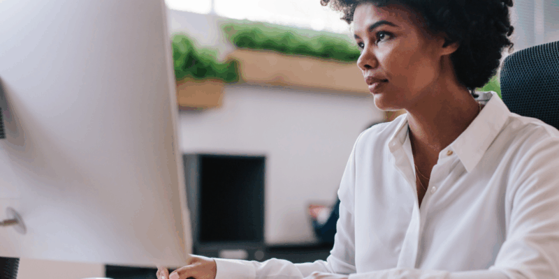 Black woman sitting at computer with a frustrated look | Dealing with a toxic boss