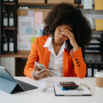 Black woman looking exhausted at work desk | Is chronic fatigue a real thing