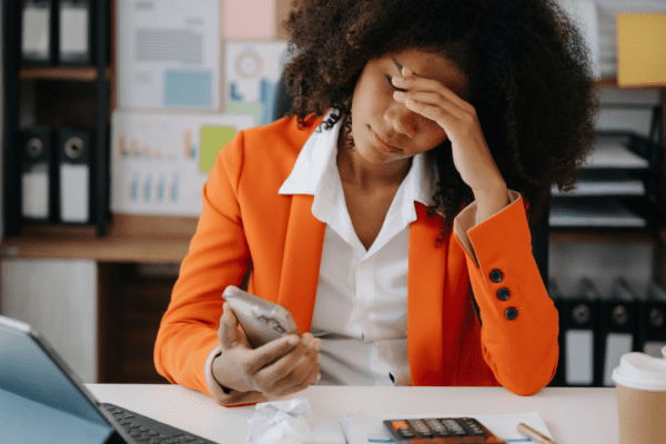Black woman looking exhausted at work desk | Is chronic fatigue a real thing