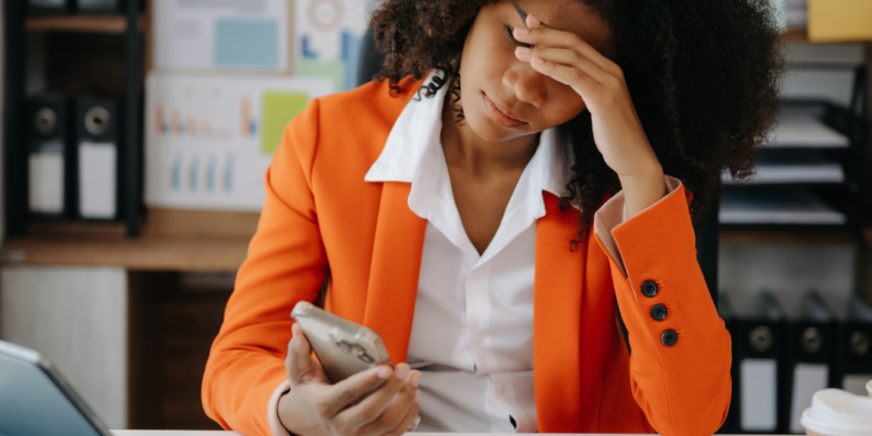 Black woman looking exhausted at work desk | Is chronic fatigue a real thing