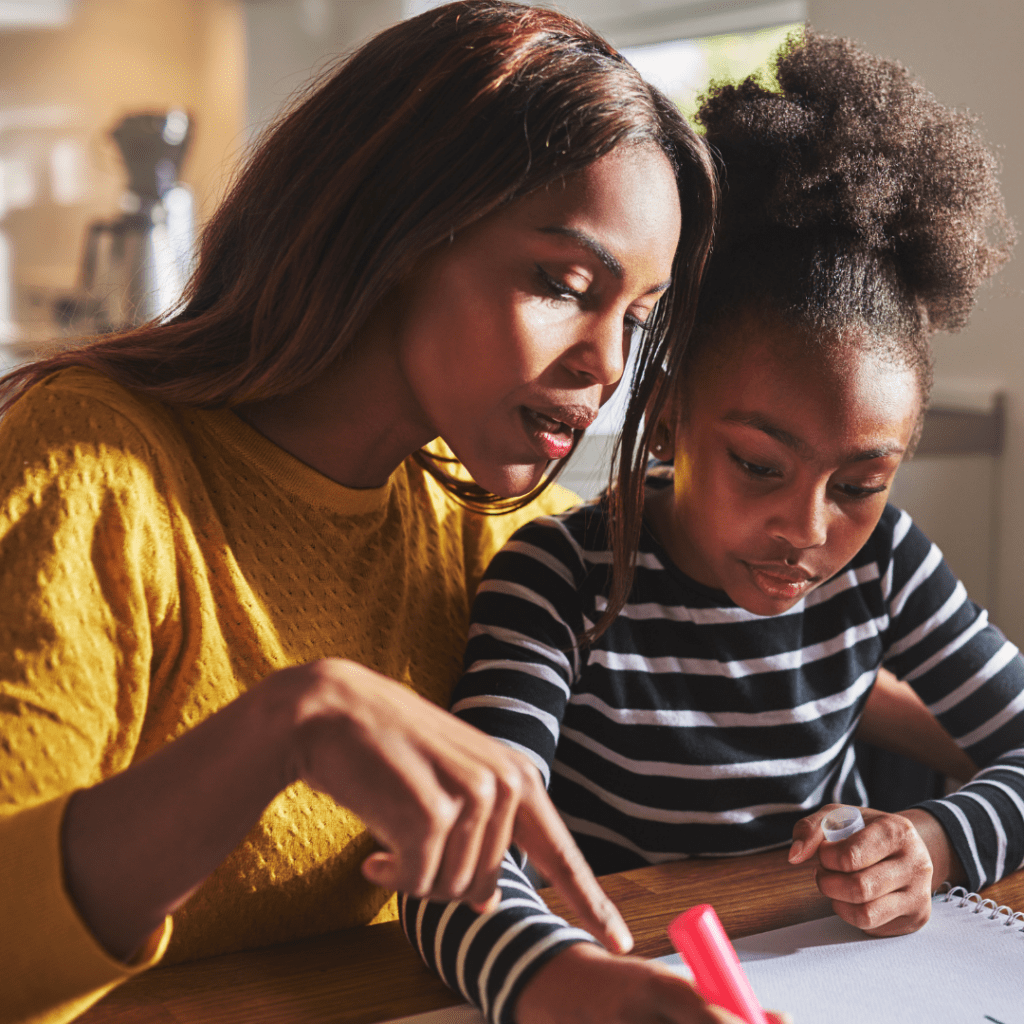 Black mother helping daughter with art project at the table } Emotionally drained